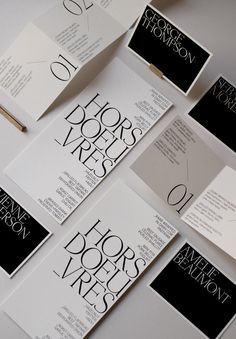 several black and white brochures are laid out on a table