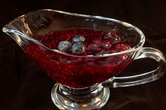 a glass pitcher filled with red liquid on top of a table