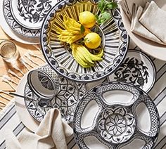 a table topped with plates and bowls filled with fruit