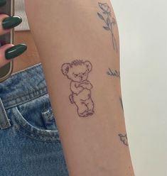 a woman's arm with a small tattoo of a teddy bear