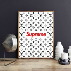 a poster with the word supreme on it next to some vases and a lamp