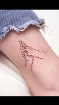 a woman's foot with a tattoo on it that has a drawing of a praying hand