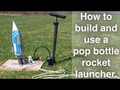 a rocket sitting on top of a field next to a power cord and plugged into an outlet