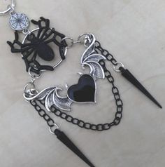 Rearview mirror charm made with a spider web connector charm, a black spider, a heart with wings and horns, and 2 black spike charms, as shown in the pictures. Measures about 5 inches from the rearview down. Includes the chain to hook onto the rearview mirror. Very unique and beautiful goth accessory! Heart With Horns, Gothic Car, Rearview Mirror Charm, Wings Black, Wings And Horns, Goth Accessories, Rear View Mirror Charm, Heart With Wings, Black Spider