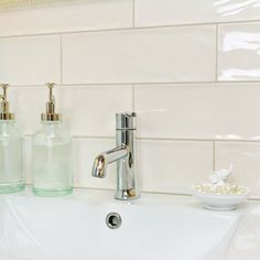 a bathroom sink with soap dispensers and toothbrushes on the counter