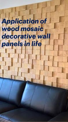 a black leather couch sitting in front of a wooden wall with wood squares on it