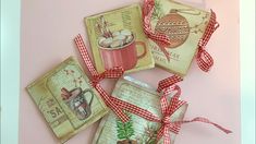 four christmas cards tied together with red ribbon on pink background, decorated with coffee mugs and ornaments