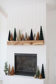 a fireplace with christmas trees on the mantel