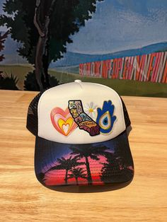 Show your California pride and score style points with The California Love Trucker Hat! Hand-crafted in our Laguna Beach storefront, this black and white trucker hat features an assortment of patches. Rock it at the beach or on the streets for a unique and playful look. Adult size, a Cactus Jane original Fun Summer Snapback Hat With Patches, White Patches Hat For Summer, Summer Adjustable Snapback Hat With Patches, Adjustable Summer Snapback Hat With Patches, Adjustable White Hat With Patches, Casual White Trucker Hat For Festival, White Trucker Hat For Summer Festival, White Snapback Trucker Hat For Festivals, Multicolor Trucker Hat For Summer