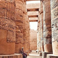 a person sitting in front of some very large columns