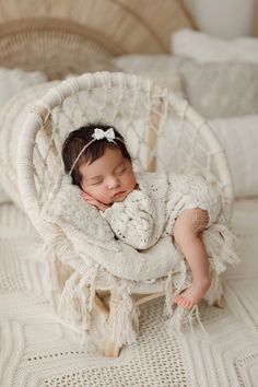 a baby is sleeping in a white chair