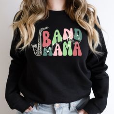 Looking for a Marching Band Mom sweatshirt? This sweatshirt is perfect for the mother of a saxophone player who is rocking the band mom life. Makes a great gift idea for a band senior mom for birthday, Christmas, Mother's Day, and more. This cute Saxophone Band Mom sweatshirt is a super sooooft and oh so comfy high quality unisex sweatshirt. It makes THE PERFECT go-to shirt all holiday season long. All colors are a 50 cotton/50 poly blend and runs true to size. This combination helps designs come out looking fresh and beautiful. The collar is ribbed knit, so it retains its shape even after washing. There are no itchy side seams on these sweaters. Our retro band sweatshirts are also super soft, cozy, and comfy especially on a winter day. Makes a great gift for your mom, sister, wife, best f Senior Band Shirts, Marching Band Shirts Ideas, Cotton Letter Print Sweatshirt For Concert, Marching Band Mom Gifts, Marching Band Mom Shirts, Band Mom Shirts Ideas, Band Sweatshirts, Band Parent Shirts, Band Mom Shirts Ideas Saxophone