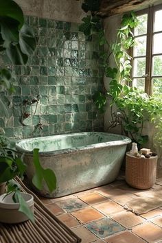 an old bathtub is surrounded by greenery in this rustic bathroom with green tiles on the walls and floor