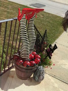 a potted plant with ladybug legs and stockings on it sitting next to a fence