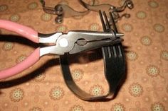 a pair of pink handled scissors sitting on top of a brown and white table cloth