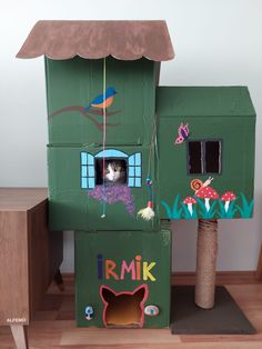 a cardboard house with a cat in the window