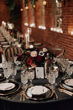 the table is set with place settings and flowers in vases, plates, and napkins