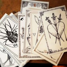 four playing cards with drawings on them sitting next to each other in front of a pile of money