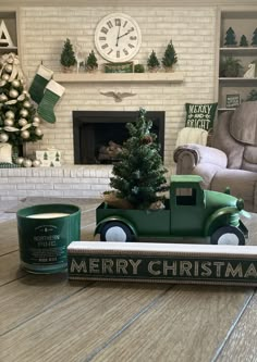 a green toy truck with a christmas tree in the back sits next to a can of paint