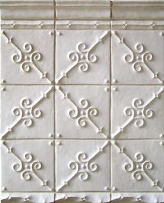 a white tile with decorative designs on it