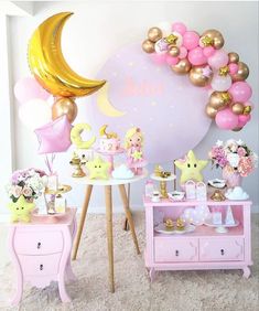 a pink and gold baby shower party complete with balloons, stars, moon, and other decorations