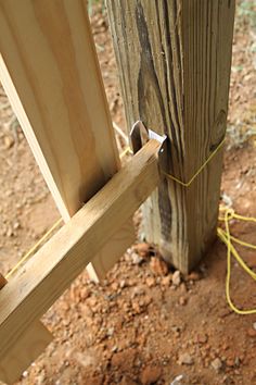 a close up of a wooden post with a yellow string attached to the top and bottom