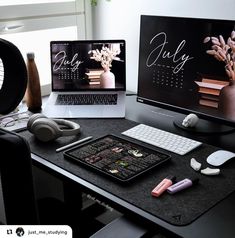 two computer screens sitting on top of a desk next to a laptop and headphones