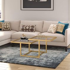 a living room with a couch, coffee table and pictures on the wall above it