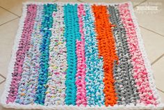 a multicolored crocheted rug is on the floor next to a tiled floor