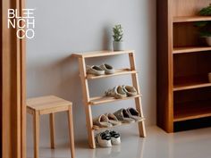 there is a shelf with shoes on it next to a stool and potted plant