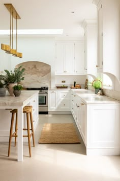 a kitchen with white cabinets and counter tops next to a rug on the floor in front of an oven