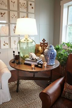 a living room filled with furniture and a table topped with vases on top of it