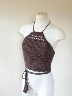 a mannequin wearing a crocheted halter top with tassels