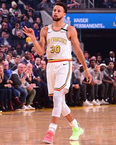 the basketball player is about to pass the ball in front of an audience at a game