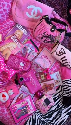 the contents of a pink bag are laying on a zebra - print blanket with other items