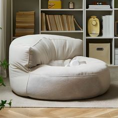 a white bean bag chair sitting in front of a bookshelf