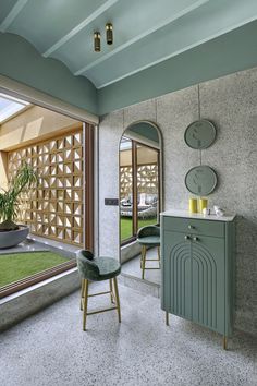 a living room with green furniture and large windows