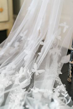 an umbrella with white flowers on it sitting next to a black and white table cloth