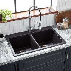 a kitchen sink with two faucets on the side and granite counter tops in front