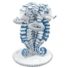 a blue and white sea horse statue on a white base