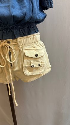 The Delia short (ivory) offers a stylish and practical Cargo style with a comfortable and versatile slouch fit. The elastic waist and adjustable string provide a perfect fit, while the 100% cotton material ensures a lightweight and breathable option for all-day wear. Upgrade your wardrobe with this must-have piece. Summer Bottoms With Cargo Pockets, Cotton Cargo Shorts With Pockets For Vacation, Summer Beach Cargo Shorts In Khaki, Summer Beach Khaki Cargo Shorts, Khaki Cargo Shorts For Summer Beach, Cream Cotton Utility Bottoms, Spring Beach Cargo Shorts In Cotton, Cream Cotton Drawstring Bottoms, Cream Cotton Bottoms With Drawstring