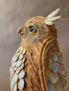 a close up of a statue of a bird with feathers on it's head