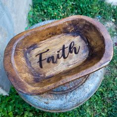 a wooden bowl with the word faith carved into it