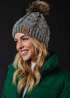 The pom hat that has us ready for winter! This stunning gray knit fleece lined pom hat will pair with all of your winter looks this coming season. Gray cable knit hat Subtle light gray knit detail throughout Natural faux fur pom accent Fleece lined Crown patch on the left side One size Designed in the U.S.A. Produced in China.  100% Acrylic Knitted Hats Kids, Knit Hat For Men, Knit Jewelry, Cable Knit Hat, Gray Winter, Blouse Tank Top, Winter Hats For Women, Knitting For Kids, Pom Pom Hat