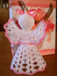 a crocheted angel ornament hanging from a card