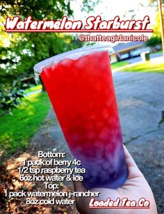 a person holding up a red drink in front of the camera with information about it