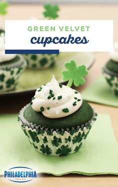 green velvet cupcakes with white frosting and shamrock decorations on top, sitting on paper napkins