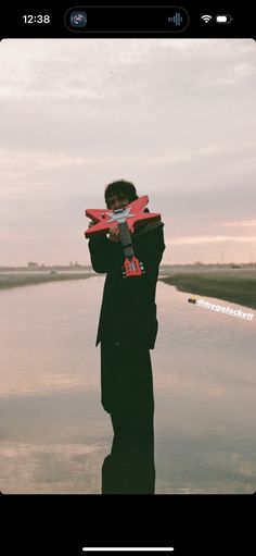 a person standing in the water holding a kite