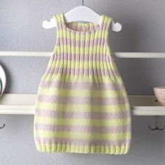 a knitted baby dress hanging on a hook