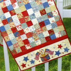 a red, white and blue quilt hanging on a fence